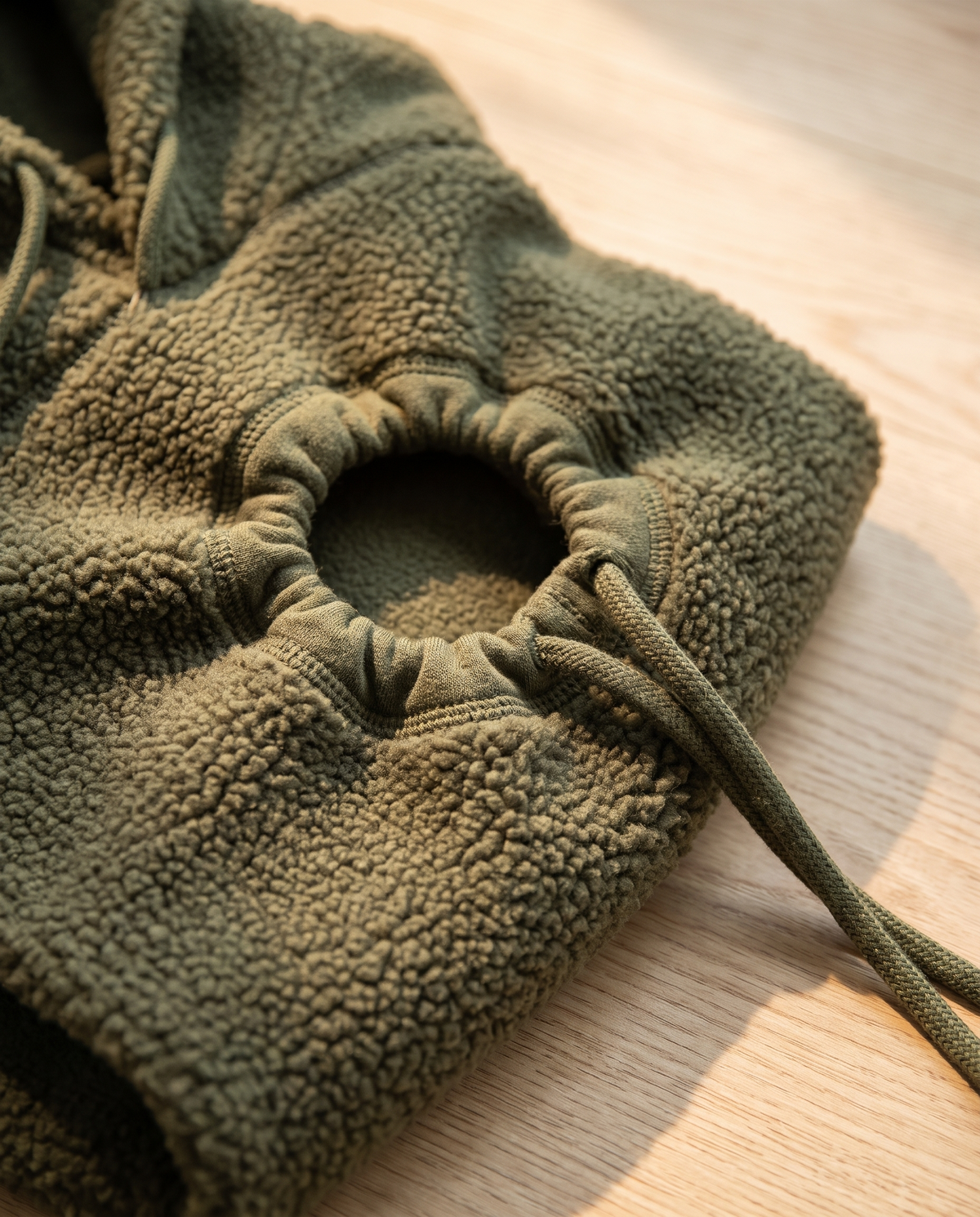 Detail of the gathered round opening and drawcord on the carrier hoodie fleece